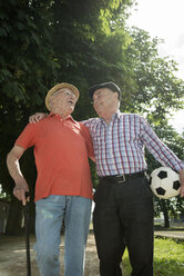Zwei alte Freunde gehen im Park spazieren und spielen Fußball - UUF000712