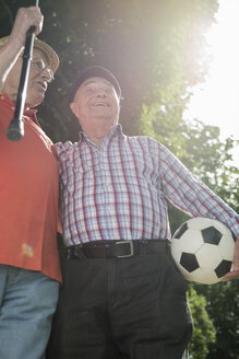 Zwei alte Freunde gehen im Park spazieren und spielen Fußball - UUF000716