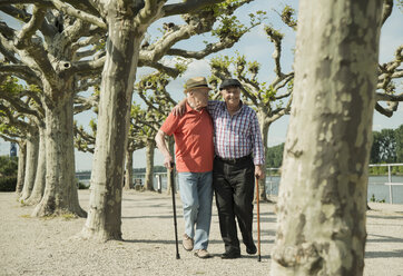 Deutschland, Rheinland-Pfalz, Worms, zwei alte Männer gehen Arm in Arm an der Rheinuferpromenade spazieren - UUF000732