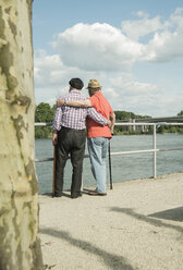 Deutschland, Rheinland-Pfalz, Worms, zwei alte Männer stehen Arm in Arm und schauen auf den Rhein, Rückansicht - UUF000734