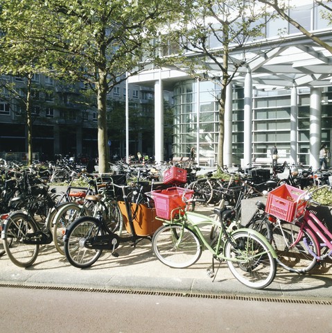Die Niederlande, Amsterdam, Fahrräder vor einem modernen Bürogebäude,, lizenzfreies Stockfoto