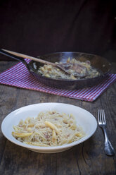 Teller und Bratpfanne mit fingerförmigen Kartoffelknödeln mit Sauerkraut und Speck auf Tuch - LVF001367