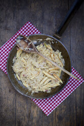 Bratpfanne mit fingerförmigen Kartoffelknödeln mit Sauerkraut und Speck auf Tuch - LVF001369