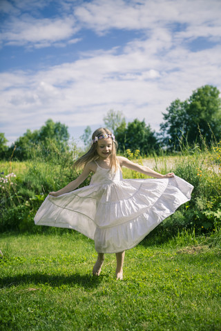 Mädchen im weißen Sommerkleid auf der Wiese, lizenzfreies Stockfoto