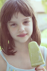 Portrait of daydreaming girl with green ice lolly - LVF001357