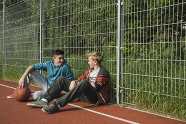 Zwei Jungen mit Basketball lehnen am Zaun - UUF000771