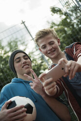 Two friends with soccer ball taking selfie - UUF000779