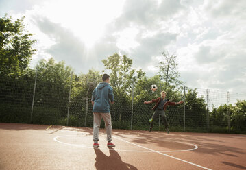 Zwei Jungen spielen Fußball - UUF000757