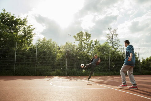 Zwei Jungen spielen Fußball - UUF000758