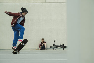 Zwei Jungen mit BMX-Rad und Skateboard auf dem Parkdeck - UUF000794