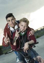 Zwei Jungen mit BMX-Rad und Kopfhörern - UUF000798