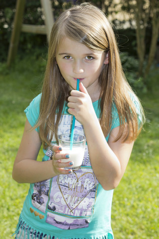 Porträt eines Milch trinkenden Mädchens mit Trinkhalm, lizenzfreies Stockfoto