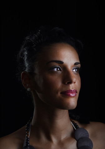 Porträt einer jungen Frau vor einem schwarzen Hintergrund, lizenzfreies Stockfoto