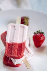 Drei Erdbeer-Joghurt-Eis am Stiel und Erdbeeren auf einem Teller, Nahaufnahme - SBDF000979