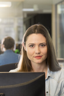 Portrait of smiling business woman at workplace - FKF000567