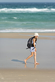 Australien, New South Wales, Pottsville, Mädchen mit Rucksack läuft am Strand - SHF001374