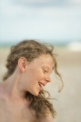 Australien, New South Wales, Pottsville, lächelnder Junge mit langen Haaren am Strand - SHF001376