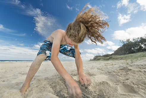 Australien, New South Wales, Pottsville, Junge gräbt in Sand am Strand - SHF001359