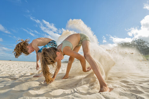 Australien, New South Wales, Pottsville, Junge und Mädchen graben im Sand am Strand - SHF001401