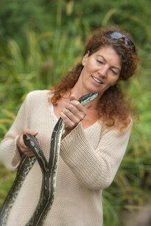 Australien, New South Wales, Wanganui, Frau hält einen Teppichpython - SHF001365