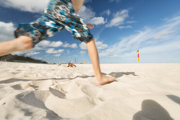 Australien, New South Wales, Pottsville, Junge läuft im Sand am Strand - SHF001390