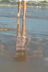 Australien, New South Wales, Pottsville, Beine eines Mädchens mit Spiegelungen im Sand am Strand - SHF001392