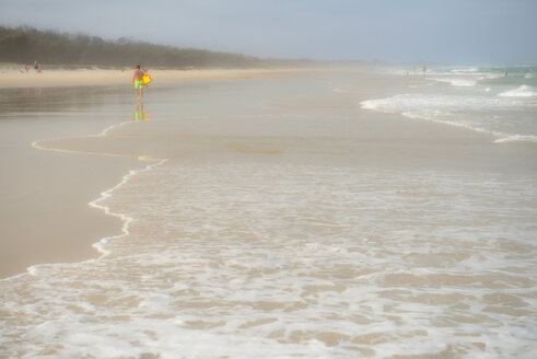 Australien, New South Wales, Pottsville, nebliger Strand mit Wellenbrecher und einem Surfer in der Ferne - SHF001394