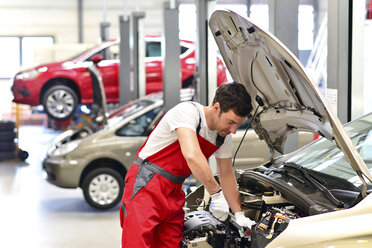 Automechaniker in einer Werkstatt bei der Arbeit am Auto - LYF000043