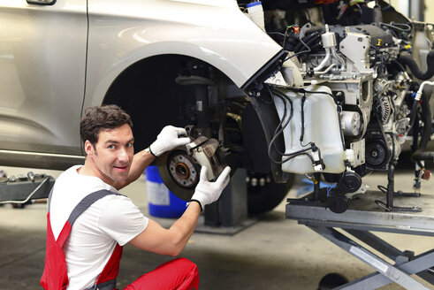 Automechaniker in einer Werkstatt bei der Arbeit am Auto - LYF000046