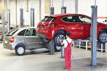 Automechaniker in einer Werkstatt beim Reifenwechsel - LYF000047