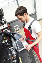 Automechaniker in einer Werkstatt mit modernen Diagnosegeräten - LYF000051