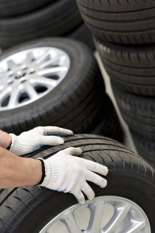 Nahaufnahme eines Automechanikers mit Reifen, lizenzfreies Stockfoto