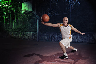 Basketballspieler auf einem Straßenbasketballplatz bei Nacht - VTF000275