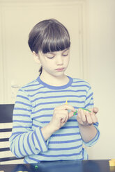 Porträt eines kleinen Mädchens mit Cutter und grüner Knetmasse - LVF001415