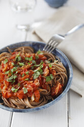 Bowl of spelt pasta with tomatoes and basil, close-up - EVGF000629