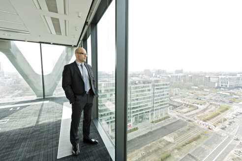 Pensive businessman on empty office floor - WESTF019471