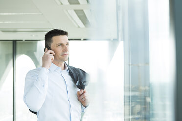 Businessman in office on cell phone - WESTF019272