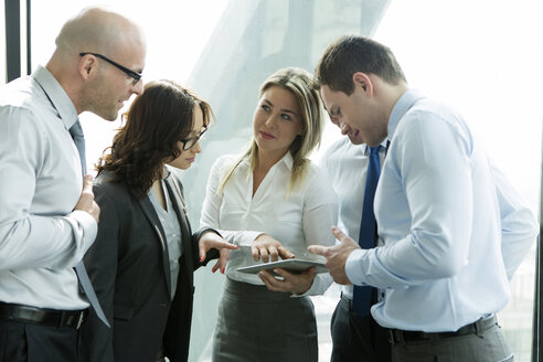 Businesspeople in office with woman using digital tablet - WESTF019280