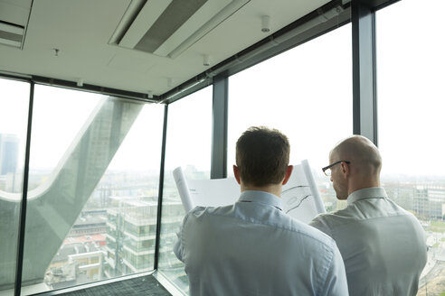 Two businessmen in office looking at blueprint - WESTF019371