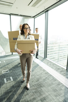 Businesspeople in office with cardboard boxes - WESTF019288