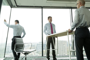 Businessmen carrying desk in new office - WESTF019290