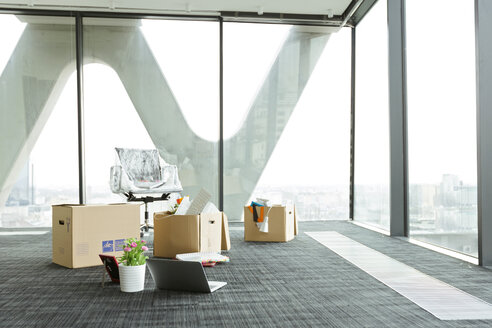 Cardboard boxes on empty office floor - WESTF019528