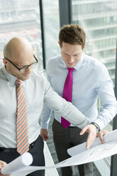 Two businessmen in office looking at blueprint - WESTF019455