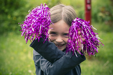 Porträt eines glücklichen kleinen Mädchens, das mit Dekorationsmaterial spielt - SARF000688