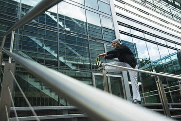 Germany, Baden-Wuerttemberg, Mannheim, mature man stretching in the city - UUF000841