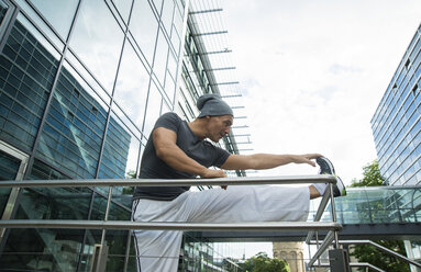 Deutschland, Baden-Württemberg, Mannheim, reifer Mann beim Stretching in der Stadt - UUF000839