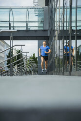 Deutschland, Baden-Württemberg, Mannheim, reife Joggerin beim Laufen in der Stadt - UUF000849