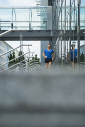 Germany, Baden-Wuerttemberg, Mannheim, mature jogger running in the city - UUF000850