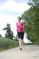 Female jogger running on field path - MAEF008380