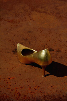 Golden stiletto on a rusty table - AXF000694